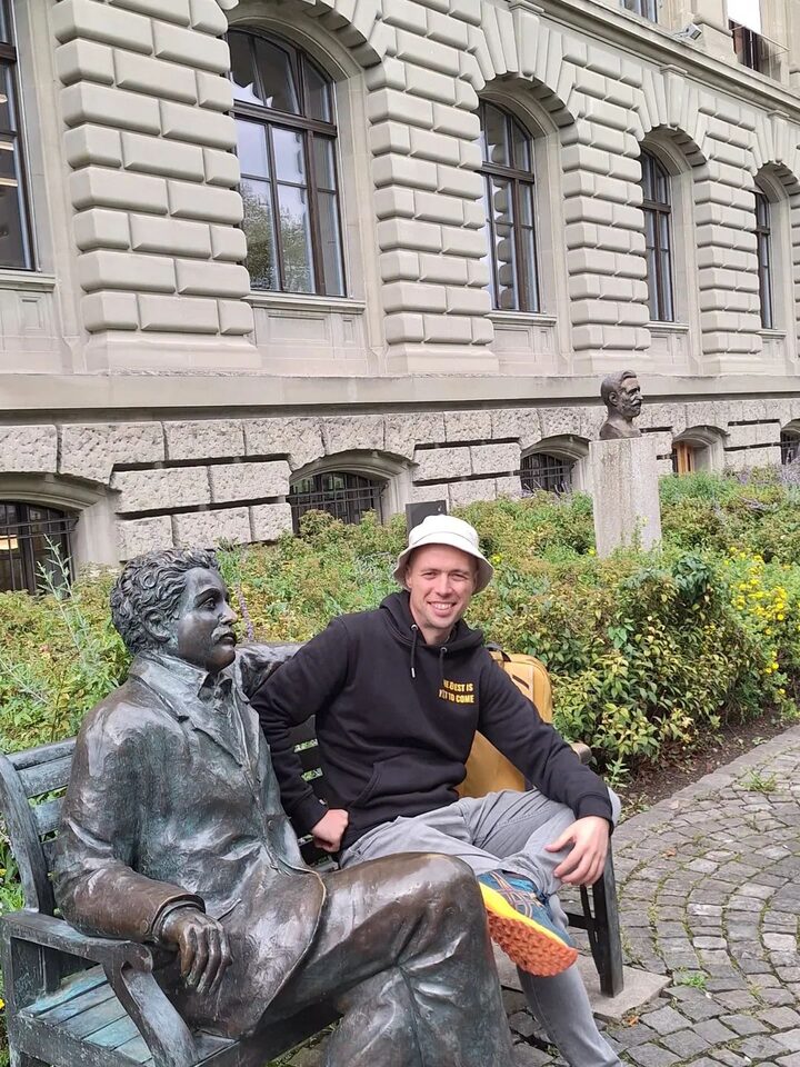 Jordan sitting on a bench next to a bronze statue of Albert Einstein